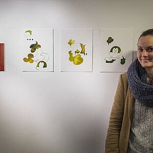 Die Künstlerin Lisa Wieder neben neben vier ihrer Bilder der Serie "BU".