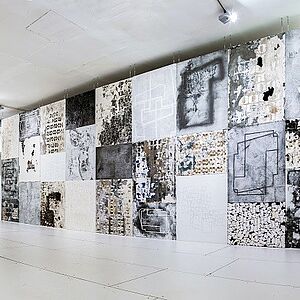 Ineinander montierte Material- und Stickbilder in grau- und blau- Tönen die als zusätzliche Wand den Raum bereichern.
