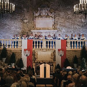 Blick vom Zuschauerraum Richtung Rednerpult, auf der Balustrade darüber ein Chor