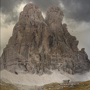 Foto von einem Berg mit zwei Gipfeln und bewölktem Himmel