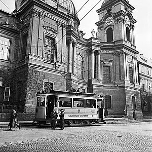 Schwarz-Weiss Fotografie von der Dreifaltigkeitskirche mit der gelben elektrischen Strassenbahn im Jahre 1940.