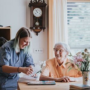 Eine Pflegerin mit Seniorin