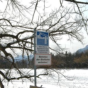 Ein zugefrorener See mit Betreten der Eisfläche verboten Schild