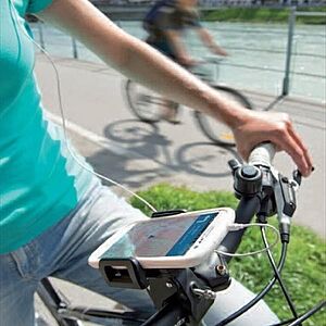 Fahrrad mit Smartphone am Lenker, im Hintergrund die Salzach