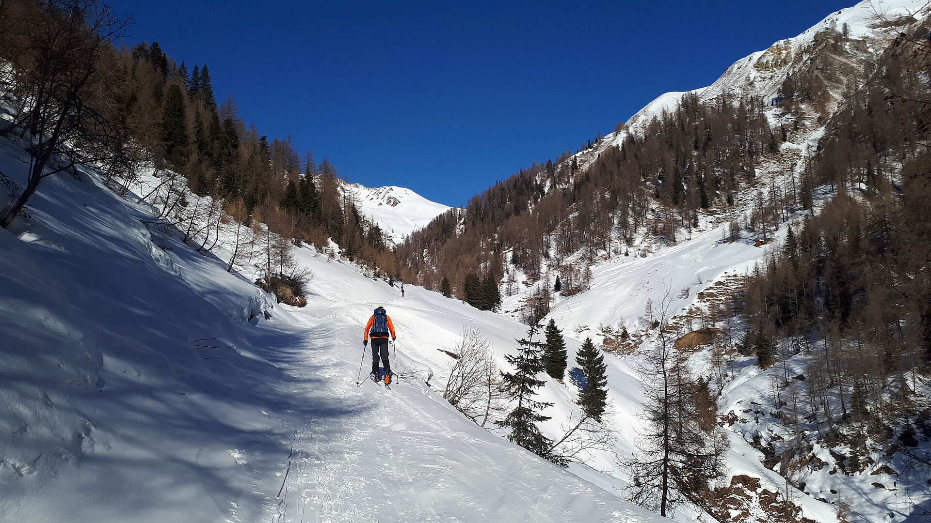 verschneite Berglandschaft - Tourengeher beim Aufstieg