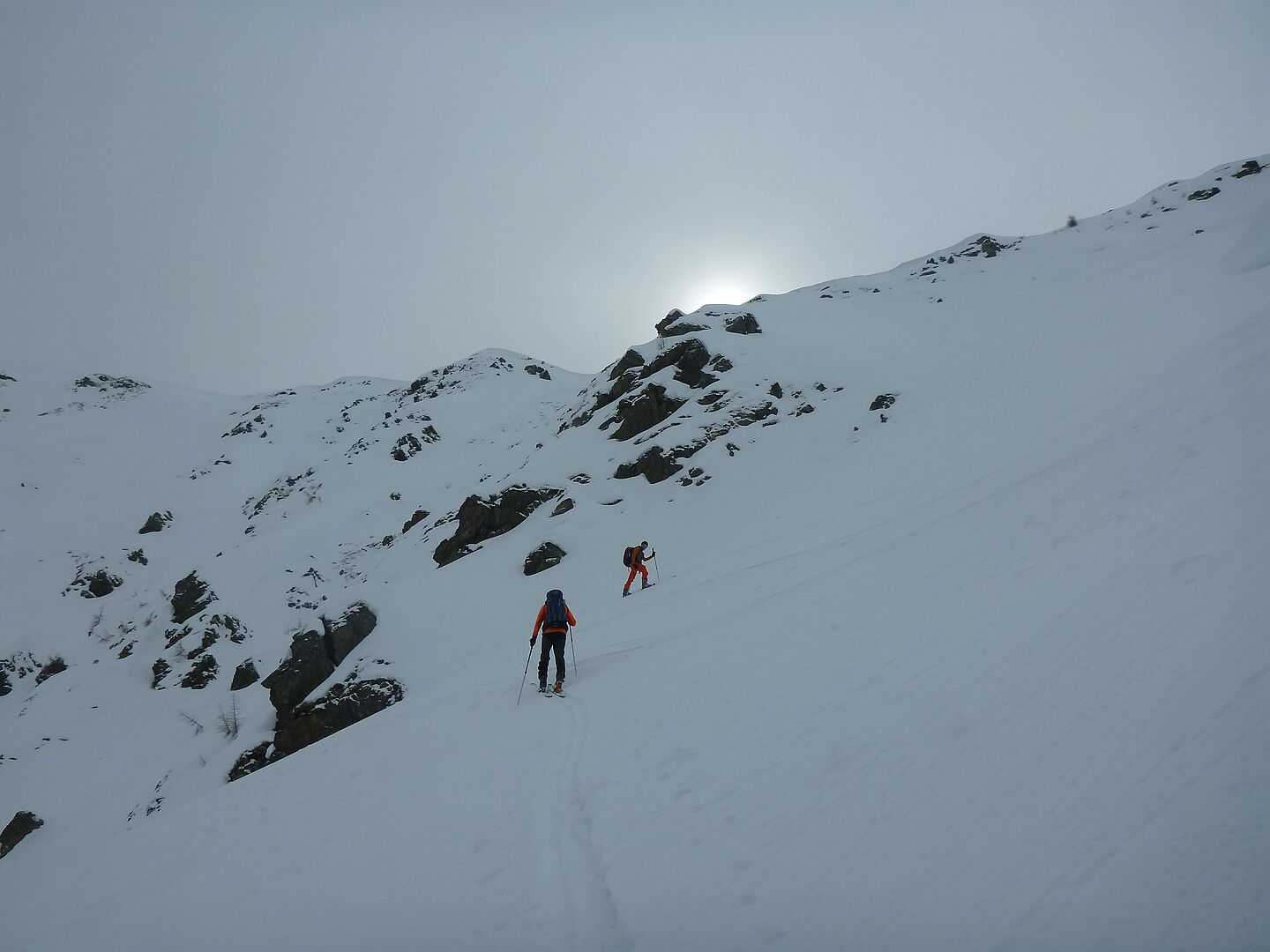 verschneite Berglandschaft - Tourengeher beim Aufstieg