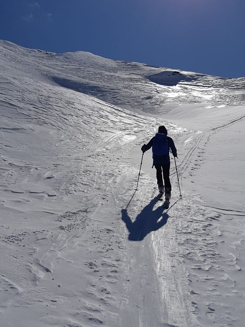 Tourengeher auf flachgepresstem Schnee im obersten Gipfelbereich 