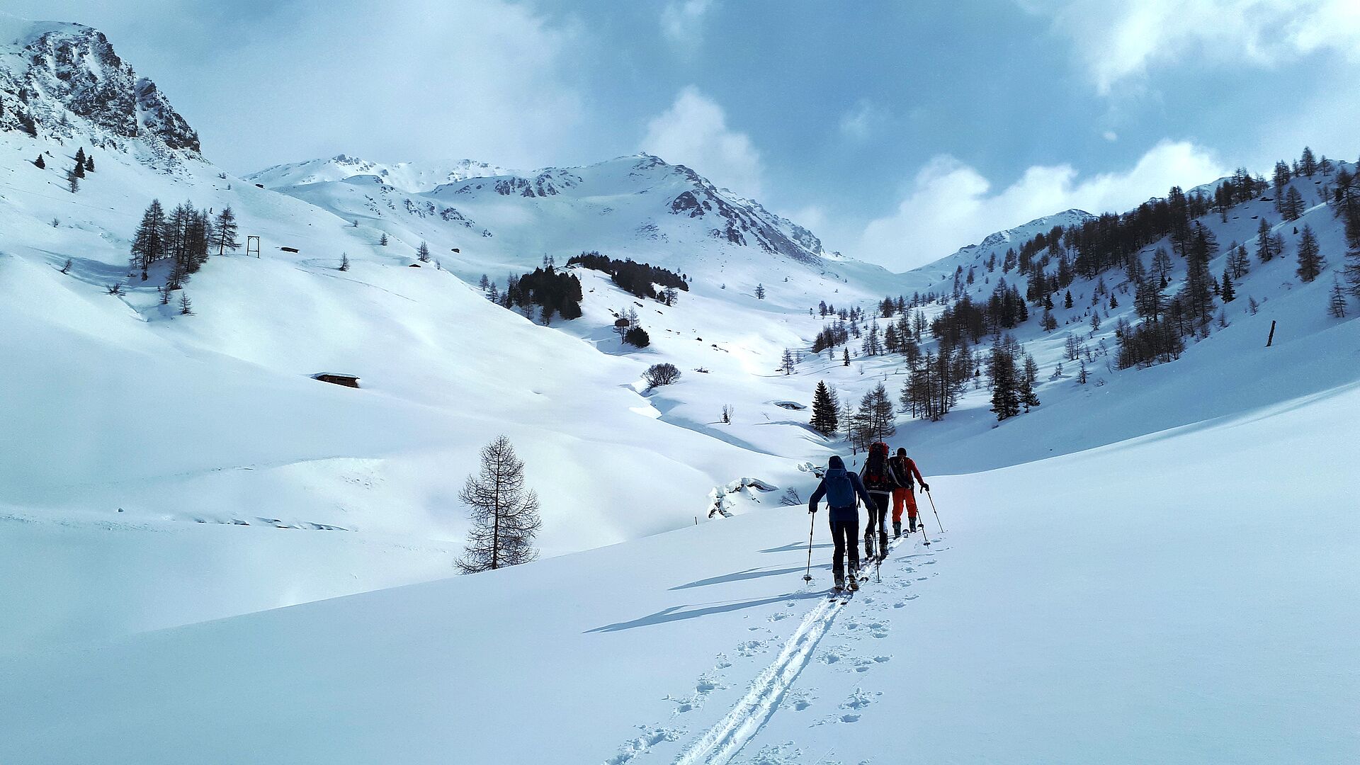 verschneite Berglandschaft - Tourengeher beim Aufstieg