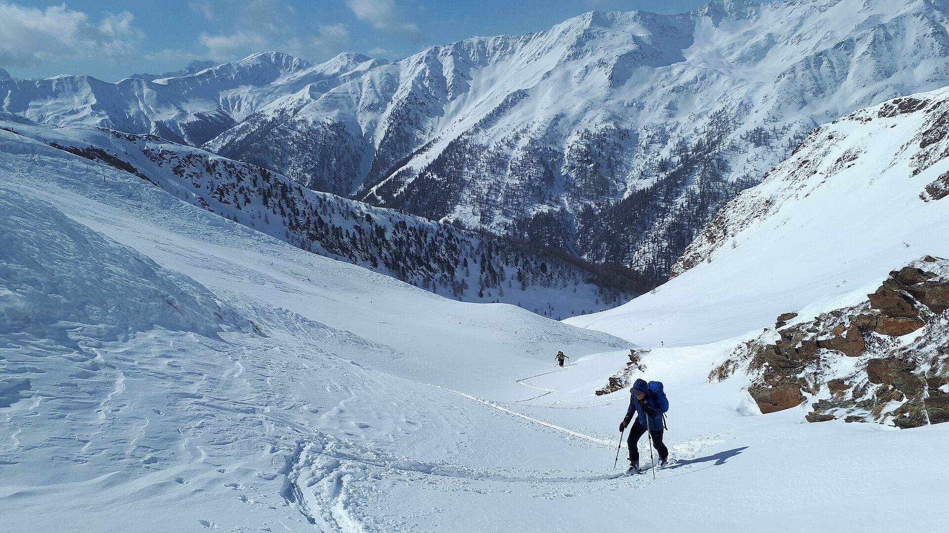 verschneite Berglandschaft - Tourengeher beim Aufstieg