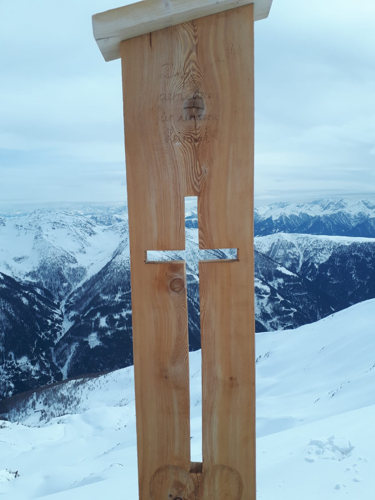 ein Hozbrett mit eingeschnitzter Kreuzforn als negativ ist das Gipfelkreuz