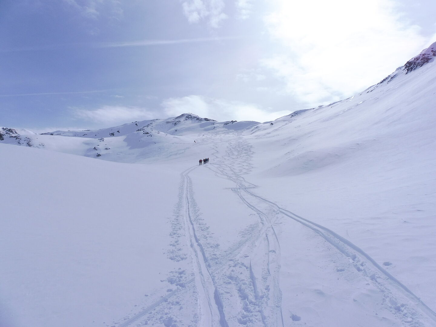 verschneite Berglandschaft - Tourengeher beim Aufstieg