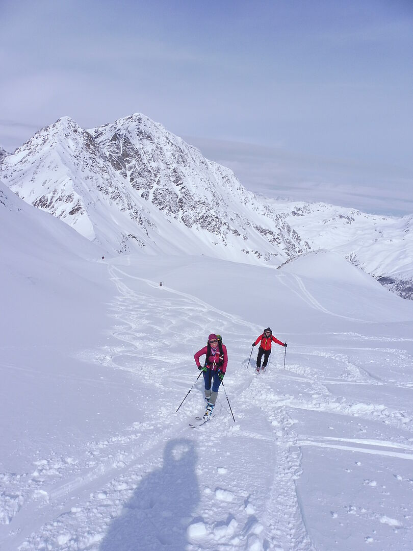 verschneite Berglandschaft - Tourengeher beim Aufstieg