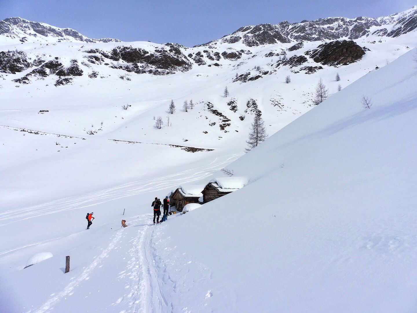 verschneite Berglandschaft - Tourengeher beim Aufstieg