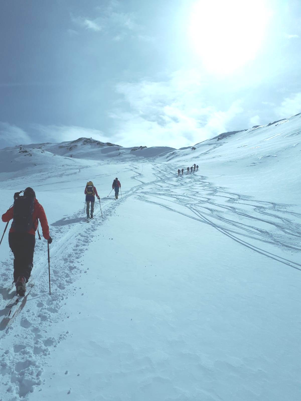 verschneite Berglandschaft - Tourengeher beim Aufstieg im Gegenlicht