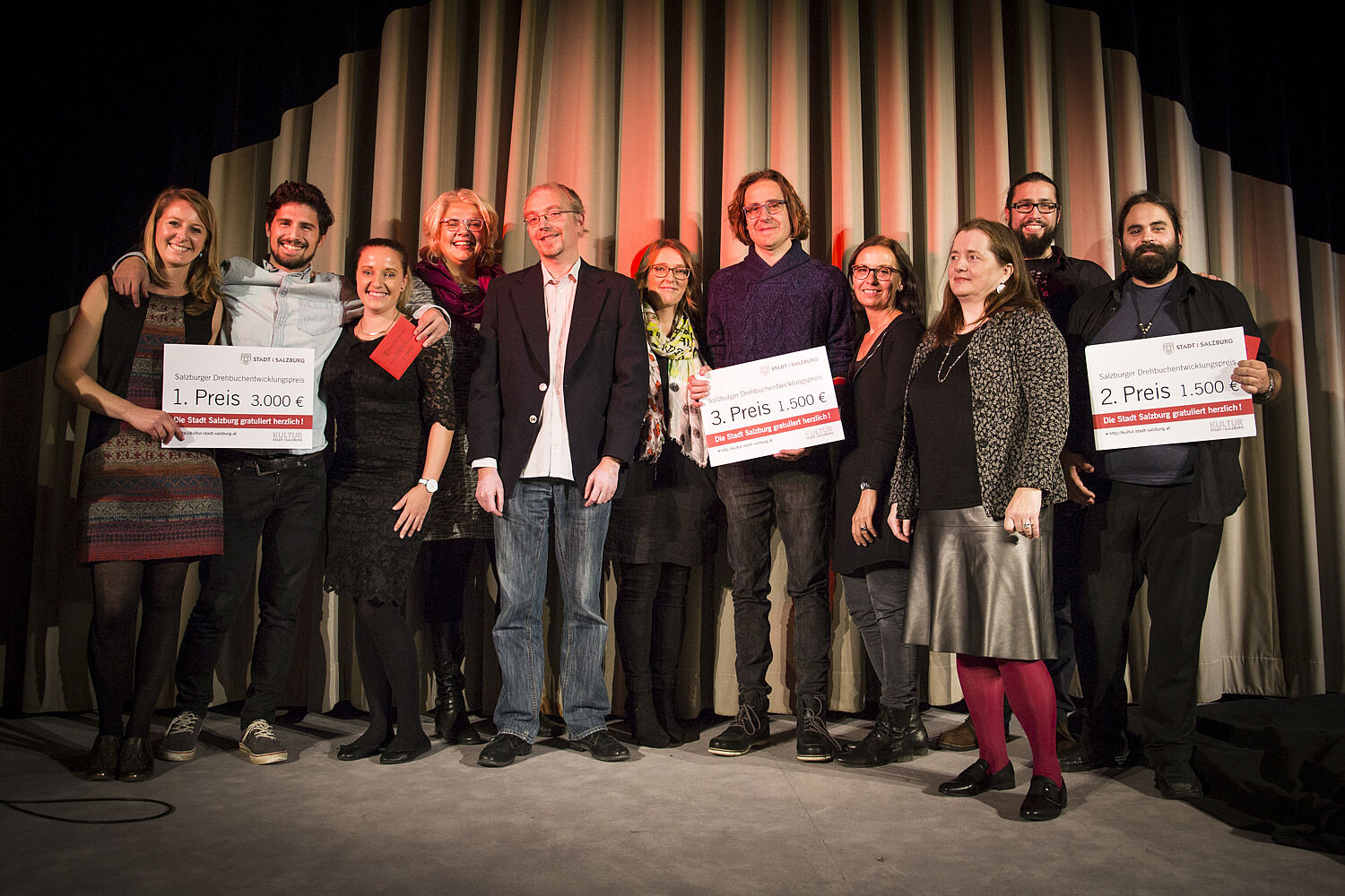 Die Gewinner und Gewinnerinnen umgeben von Gratulanten 