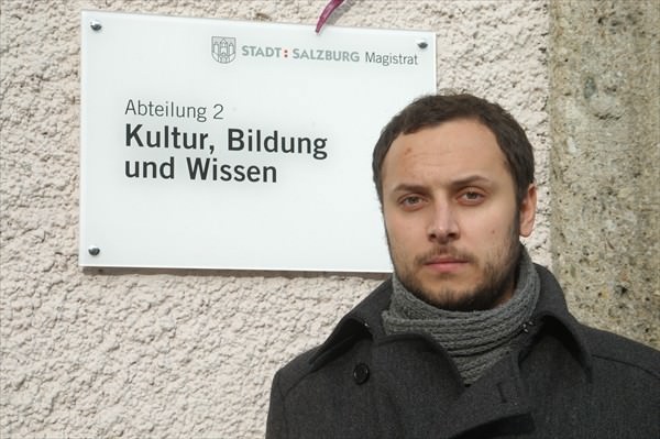Srecko Horvat Foto von Strecko Horvat neben dem Schild für die Abteilung 2 - Kultur, Bildung und Wissen neben dem Eingang zum Amtsgebäude