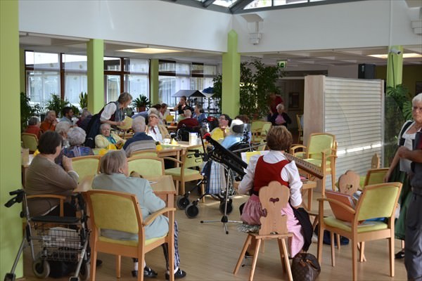 Senioren und Seniorinnen sitzen zusammen mit Musik