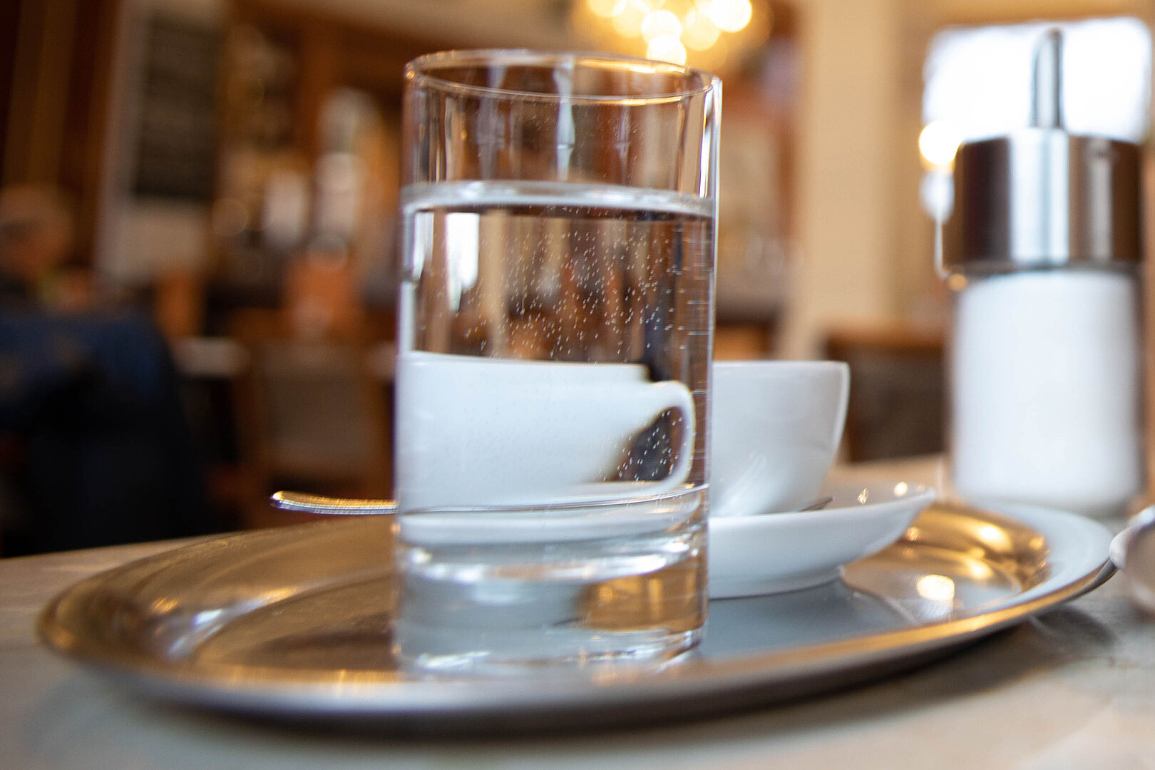 Glas Wasser zum Kaffee auf einem Serviertablett