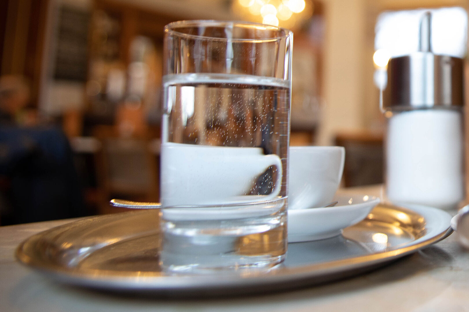 Kaffee Plausch Glas Wasser zum Kaffee auf einem Serviertablett