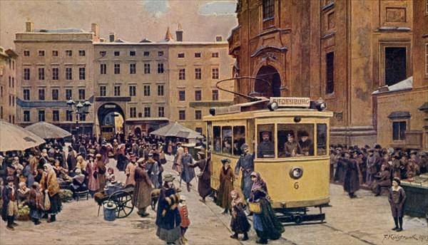 Die gelbe elektrische Strassenbahn am Universitaetsplatz mitten im Marktbetrieb.