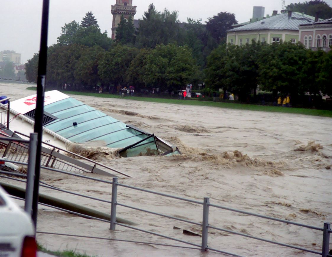 Ein Boot steckt mit dem Rumpf im Wasser. Der Fahrradweg ist übnerflutet im Jahre 2002.
