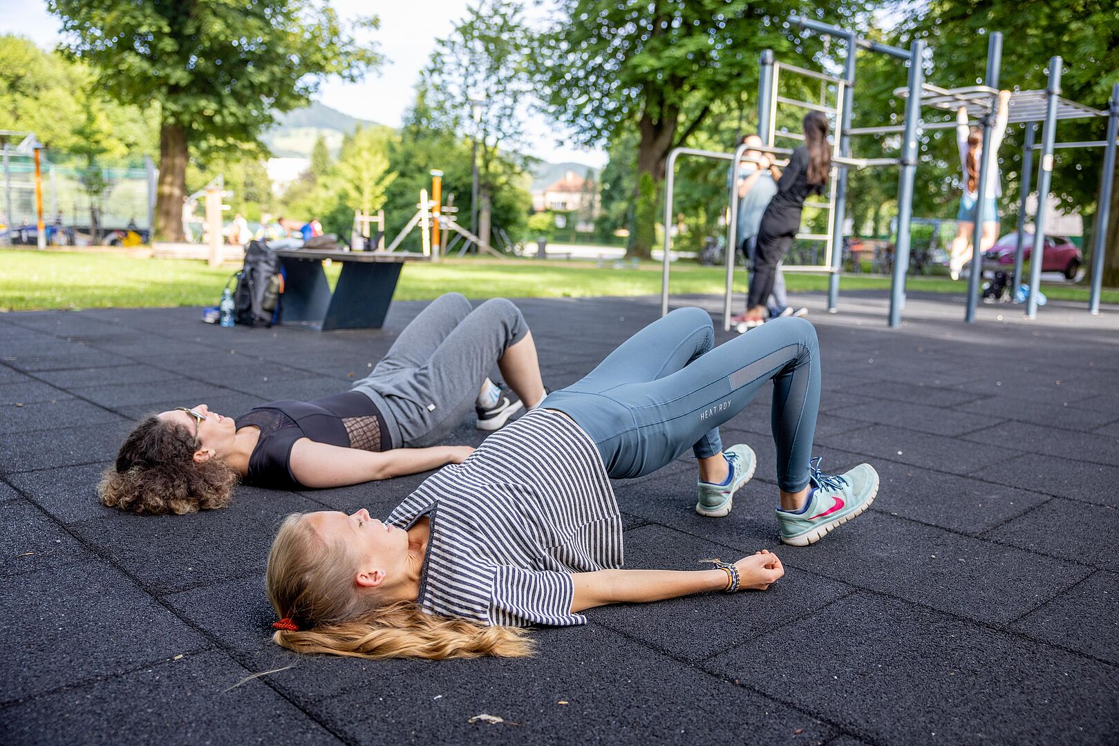 Zwei junge Mädchen machen am Boden liegend Fitness-Übungen.