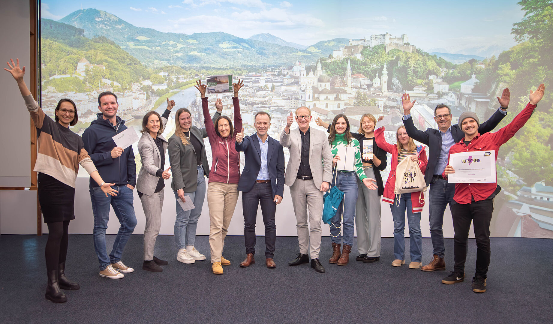 Strahlende Gesichter und Daumen hoch: Die glücklichen Gewinner:innen des Wissenstage-Gewinnspiels feiern gemeinsam mit den Sponsoren und dem Vizebürgermeister Bernhard Auinger.