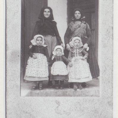 Zwei ältere Frauen mit drei kleinen Kindern