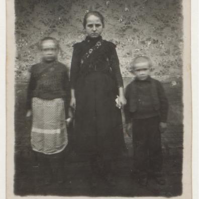 Drei Kinder vor einer tapezierten Wand