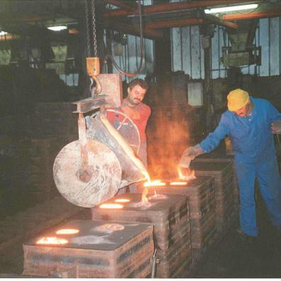 Zwei Männer bei der Arbeit in einer Glockengießerei