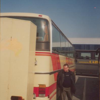 Mann neben Reisebus