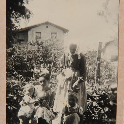 Frau mit Kindern im Garten