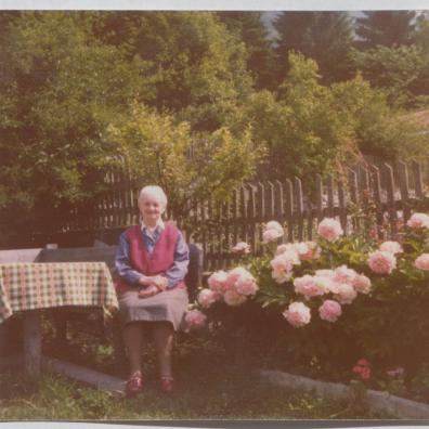 Frau in einem Garten sitzend